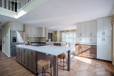 Example of a mid-sized transitional kitchen design in DC Metro with shaker cabinets, white cabinets, quartz countertops, an island and white countertops