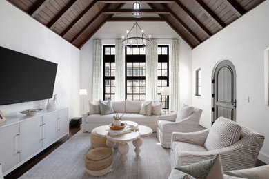 Inspiration for a beach style open concept living room with white walls and exposed beam.