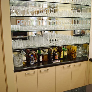 ロサンゼルスの中サイズのコンテンポラリースタイルのおしゃれな着席型バー (ガラス扉のキャビネット、御影石カウンター、アンダーカウンターシンク、ベージュのキャビネット、淡色無垢フローリング) の写真