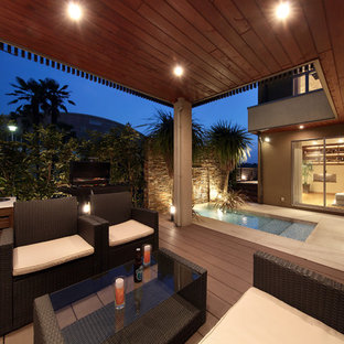 他の地域のトロピカルスタイルのおしゃれな中庭のテラス (デッキ材舗装、張り出し屋根) の写真