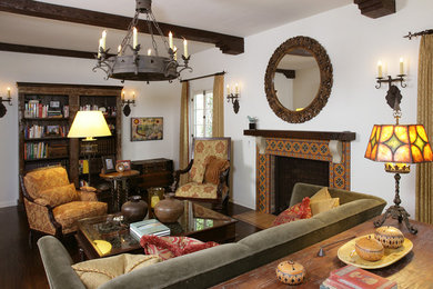 This is an example of a large mediterranean enclosed living room in Los Angeles with white walls, dark hardwood floors, a standard fireplace, a tile fireplace surround and brown floor.