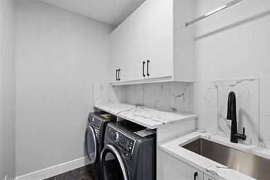 Inspiration for a contemporary laundry room remodel in Calgary with yellow backsplash and white walls