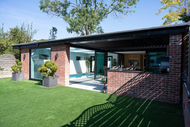 Modelo de patio grande con cocina exterior, suelo de baldosas y pérgola