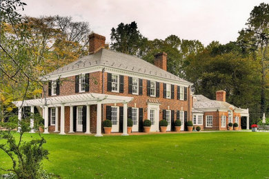 Example of a large classic red two-story brick exterior home design in New York