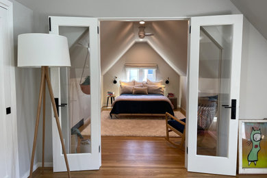 Foto de dormitorio tipo loft nórdico de tamaño medio con paredes grises y suelo de madera clara