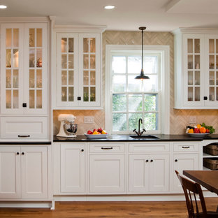 Klassische Küche mit Kassettenfronten, weißen Schränken, Kalkstein-Arbeitsplatte, Küchenrückwand in Beige und Kalk-Rückwand in Philadelphia