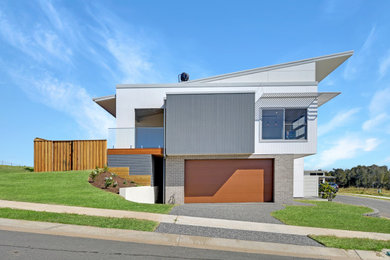 Design ideas for a large beach style two-storey white duplex exterior in Sydney with concrete fiberboard siding and a metal roof.