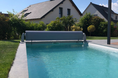 Exemple d'un piscine avec aménagement paysager latéral de taille moyenne et rectangle.