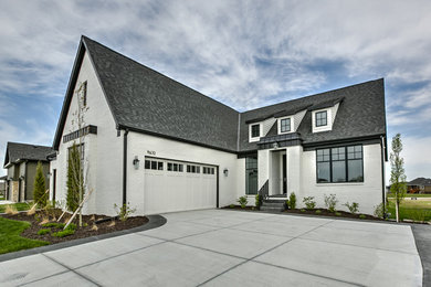 Inspiration for a farmhouse white one-story brick exterior home remodel in Other with a shingle roof