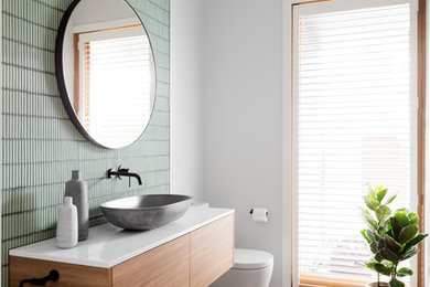 Contemporary bathroom in Melbourne with flat-panel cabinets, medium wood cabinets, a two-piece toilet, white walls, medium hardwood floors, a vessel sink, brown floor and grey benchtops.