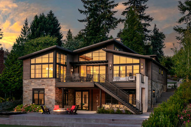 Example of a trendy backyard stone patio design with a fire pit and a roof extension
