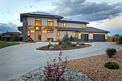 Inspiration for a large contemporary beige two-story stucco house exterior remodel in Denver with a hip roof and a shingle roof