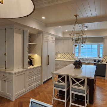 Large kitchen island with white cabinets and patterned tile backsplash in Westla