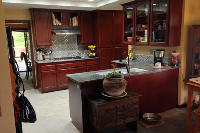 Small elegant l-shaped ceramic tile open concept kitchen photo in Los Angeles with a double-bowl sink, recessed-panel cabinets, red cabinets, quartzite countertops, gray backsplash, mosaic tile backsplash, stainless steel appliances and no island
