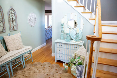Example of a small cottage chic medium tone wood floor and brown floor entryway design in Boston with green walls and a white front door