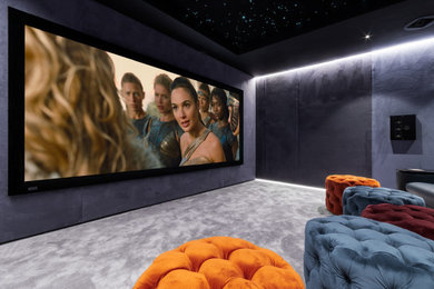 Immagine di un home theatre minimalista di medie dimensioni e chiuso con pareti blu, moquette, schermo di proiezione e pavimento grigio