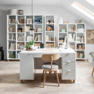 Design ideas for a medium sized modern home studio in Toronto with white walls, laminate floors, a freestanding desk and beige floors.