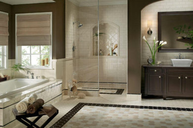 Inspiration for a mid-sized transitional master bathroom in San Francisco with recessed-panel cabinets, dark wood cabinets, a drop-in tub, an open shower, a one-piece toilet, beige tile, brown tile, porcelain tile, brown walls, mosaic tile floors, a vessel sink and solid surface benchtops.