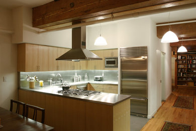 Design ideas for a small contemporary u-shaped eat-in kitchen in Seattle with flat-panel cabinets, light wood cabinets, stainless steel benchtops, stainless steel appliances and a peninsula.