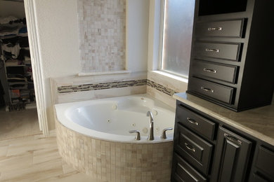 Inspiration for a large timeless master beige tile and porcelain tile porcelain tile bathroom remodel in Dallas with raised-panel cabinets, black cabinets, white walls, solid surface countertops and an undermount sink