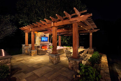 Large trendy backyard stone patio photo in Other with a fireplace and a pergola
