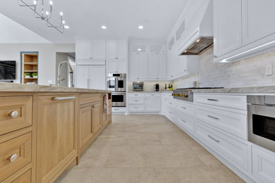 Inspiration for a large transitional l-shaped ceramic tile and gray floor open concept kitchen remodel in Houston with an undermount sink, recessed-panel cabinets, white cabinets, quartzite countertops, beige backsplash, ceramic backsplash, paneled appliances, an island and beige countertops