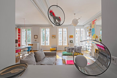 Inspiration pour une grande salle de séjour bohème ouverte avec un mur blanc, un sol en bois brun, une cheminée standard, un manteau de cheminée en pierre et aucun téléviseur.
