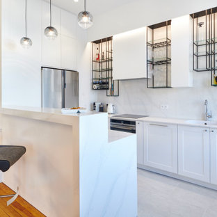Réalisation d'une cuisine parallèle design de taille moyenne avec un évier intégré, un placard à porte shaker, des portes de placard blanches, une crédence blanche, un électroménager en acier inoxydable, aucun îlot, un sol blanc et un plan de travail blanc.