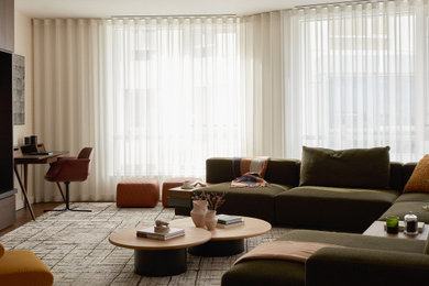 Foto di un soggiorno design di medie dimensioni e aperto con libreria, pareti beige, parquet scuro, TV nascosta e pannellatura