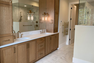 Bathroom - large transitional master beige tile and porcelain tile porcelain tile, beige floor and double-sink bathroom idea in Portland with shaker cabinets, brown cabinets, a one-piece toilet, white walls, an undermount sink, quartz countertops, a hinged shower door, white countertops and a built-in vanity
