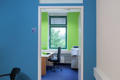 Mittelgroßes Modernes Arbeitszimmer mit Arbeitsplatz, grüner Wandfarbe, Teppichboden und freistehendem Schreibtisch in Sonstige