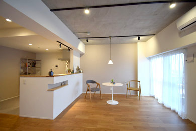 北欧スタイルのおしゃれなLDK (白い壁、標準型暖炉、茶色い床、グレーの天井) の写真