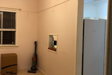 Mittelgroße Klassische Wohnküche mit weißer Wandfarbe, dunklem Holzboden und braunem Boden in Brisbane