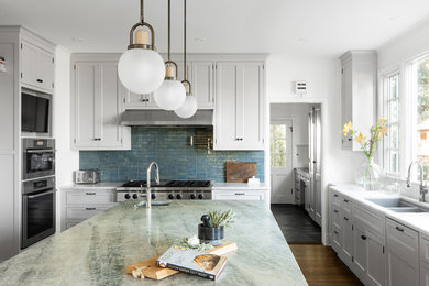 Inspiration for a huge transitional u-shaped medium tone wood floor and brown floor enclosed kitchen remodel in Portland with an undermount sink, shaker cabinets, white cabinets, quartzite countertops, blue backsplash, ceramic backsplash, paneled appliances, an island and multicolored countertops