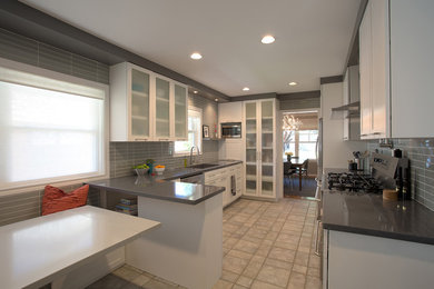 Inspiration for a small contemporary l-shaped ceramic tile and beige floor eat-in kitchen remodel in Houston with a single-bowl sink, shaker cabinets, white cabinets, quartz countertops, gray backsplash, glass tile backsplash, stainless steel appliances and no island