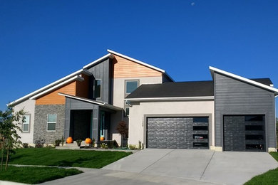 Inspiration for a large contemporary three-story mixed siding house exterior remodel in Salt Lake City with a shed roof and a shingle roof