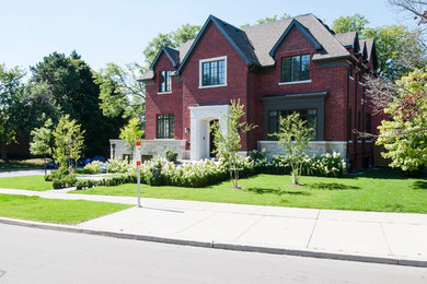 Example of a large red two-story brick house exterior design in Toronto