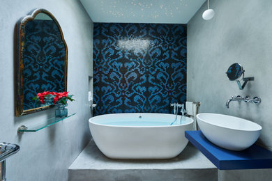 ダラスにあるエクレクティックスタイルのおしゃれな浴室 (置き型浴槽、モザイクタイル、青い壁、コンクリートの床、グレーの床) の写真