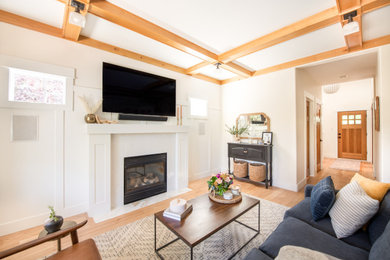 Example of a mid-sized trendy light wood floor, exposed beam and wainscoting living room design in Portland with a standard fireplace and a wall-mounted tv