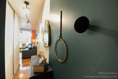 Idée de décoration pour une petite entrée design avec un couloir, un mur vert, un sol en linoléum, une porte simple, une porte verte et un sol marron.