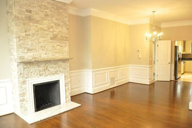 Inspiration for a mid-sized contemporary open concept medium tone wood floor living room remodel in DC Metro with beige walls, a standard fireplace and a stone fireplace