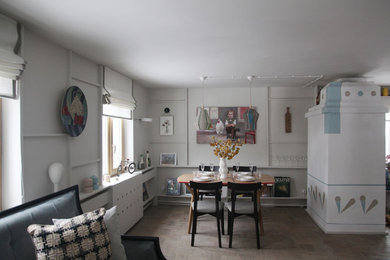 Ispirazione per una piccola sala da pranzo aperta verso il soggiorno minimalista con pareti bianche, pavimento in legno massello medio, stufa a legna e cornice del camino in intonaco