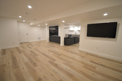 Mid-sized transitional vinyl floor basement photo in Manchester with a bar and white walls