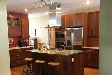 Example of a large trendy l-shaped light wood floor and brown floor eat-in kitchen design in Other with an undermount sink, shaker cabinets, medium tone wood cabinets, stainless steel appliances and an island