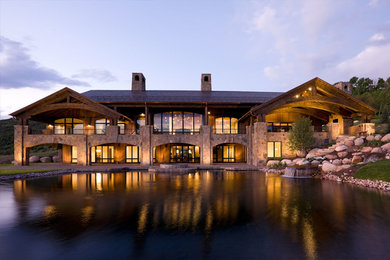 Example of a large transitional beige two-story stone exterior home design in Denver with a shingle roof
