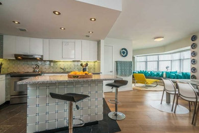 Example of a small minimalist l-shaped slate floor eat-in kitchen design in Miami with flat-panel cabinets, white cabinets, quartz countertops, an island, a drop-in sink, gray backsplash, porcelain backsplash and stainless steel appliances