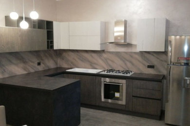 Immagine di una cucina abitabile minimalista con ante grigie