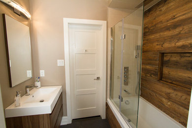 Mid-sized trendy master beige tile and porcelain tile slate floor bathroom photo in Toronto with flat-panel cabinets, medium tone wood cabinets, beige walls, an integrated sink and solid surface countertops