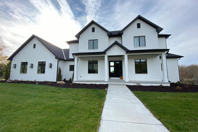 Example of a transitional two-story exterior home design in Other with a hip roof, a shingle roof and a black roof