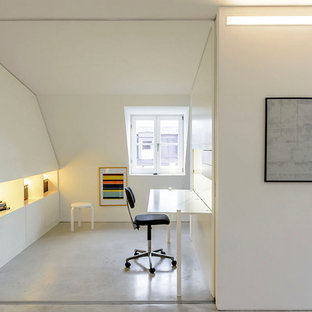 Photo of a small modern study in Munich with white walls, lino flooring and a built-in desk.